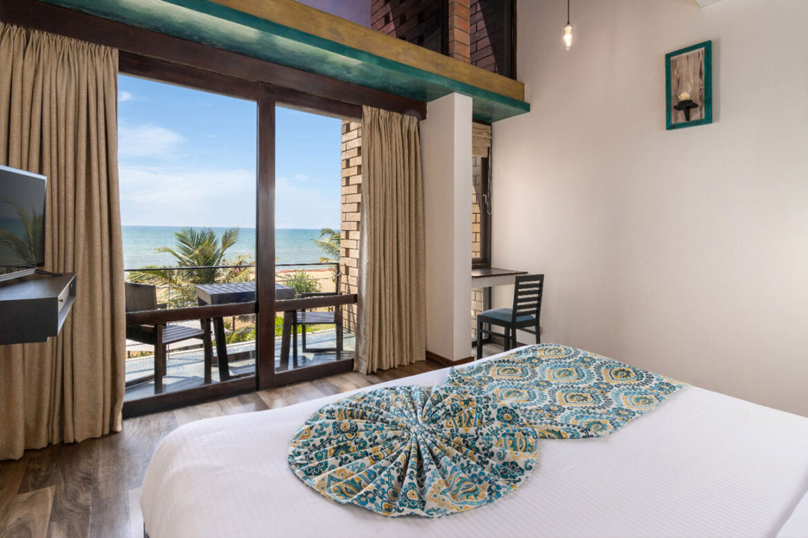 Ocean view from the bed with open curtains in the room.