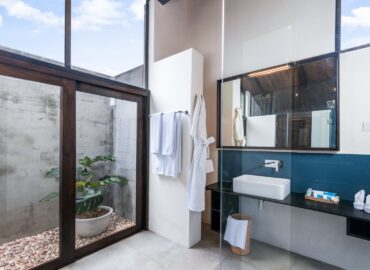 White and blue color bathroom with a bathtub, shower cubicle and a bathrobe