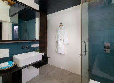 White and blue color bathroom with a bathtub, shower cubicle and a bathrobe